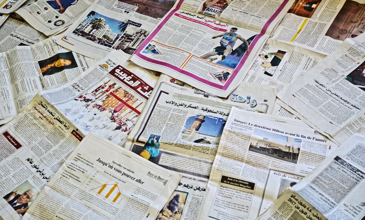 home-services-004 Close-up view of various newspapers laid out, showcasing diverse headlines and articles.