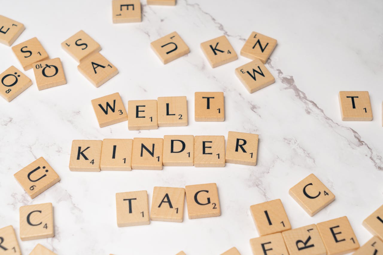 home-hero-bg Scrabble tiles forming the words Welt Kinder Tag on a marble background, symbolizing childrens day.