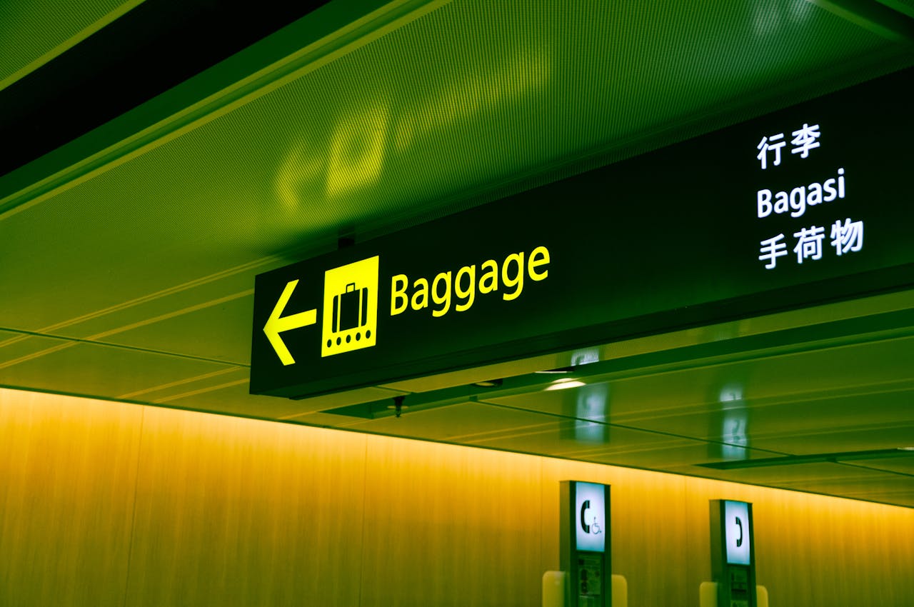home-services-01 Illuminated airport baggage sign with multilingual translations pointing direction for travelers.